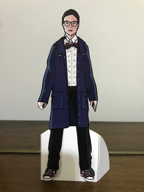 Paper doll of Osgood in a blue duffel coat, bow tie and converse