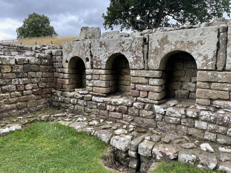 A stone wall with small arched openings.