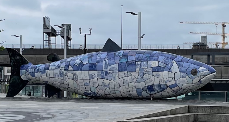 A large blue mosaic salmon statue.